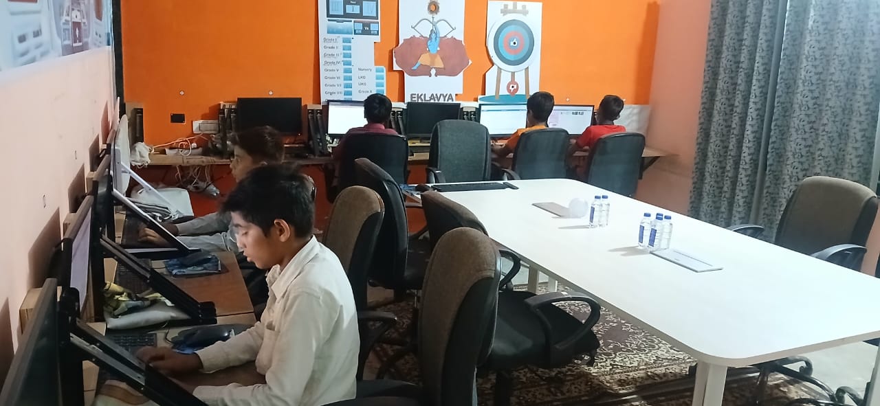 Students learning in modern computer classroom with individual workstations