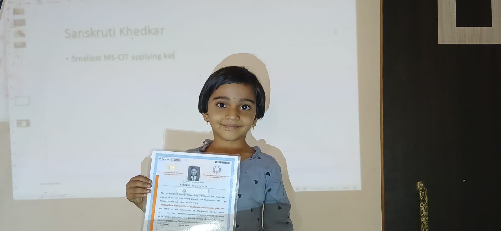 Young girl proudly holding her achievement certificate