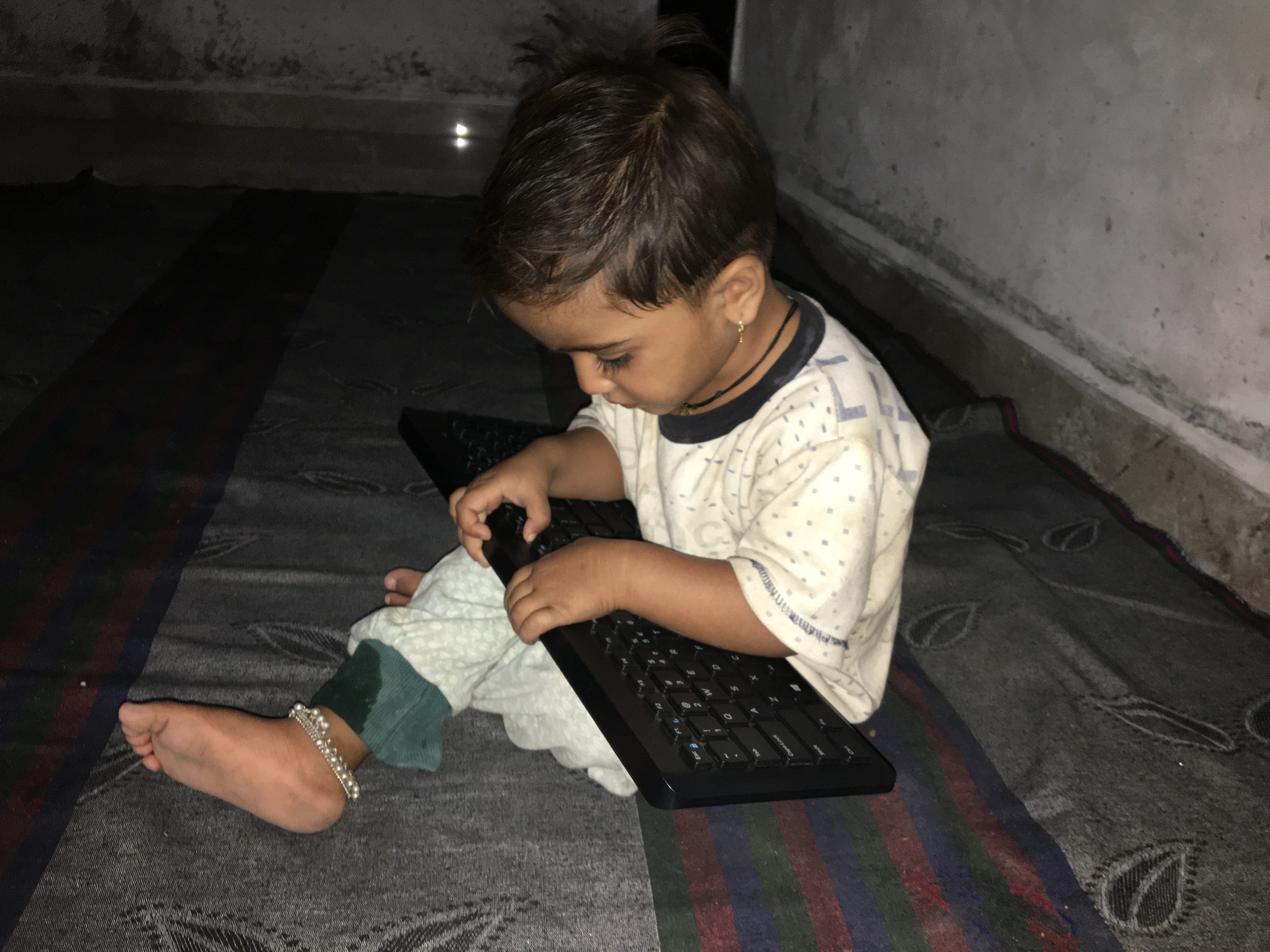 Young child learning to use laptop computer in home environment
